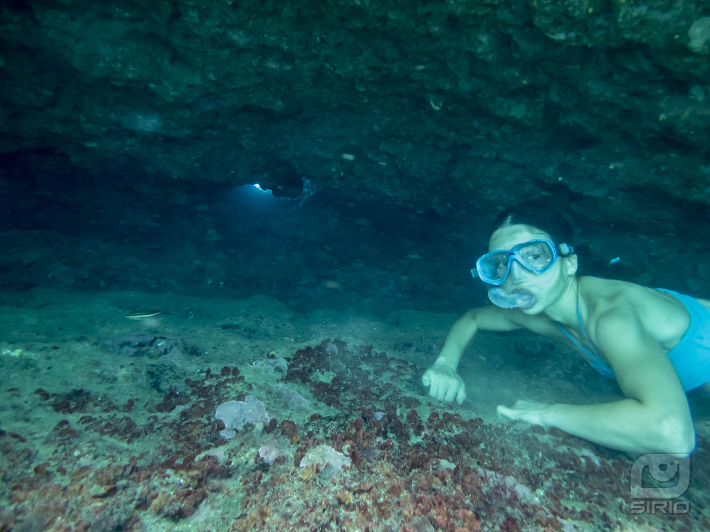 Water cave entrance with girl underwater